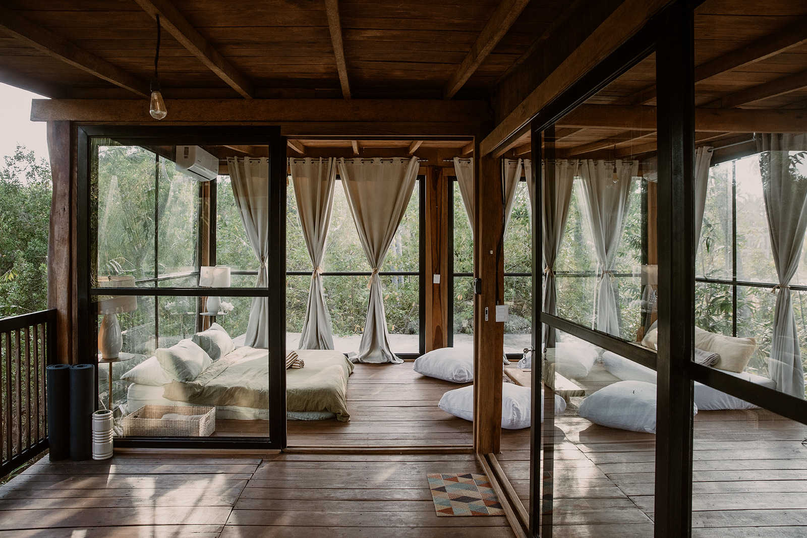 The glass-walled treehouse at Templo Saladita — copper soaking tub, palm canopy, ceiling open to the lagoon